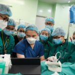 Group of doctors looking at small screen during check up.