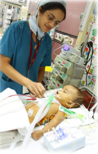 Nurse checking an infant on an operating table in a hospital.