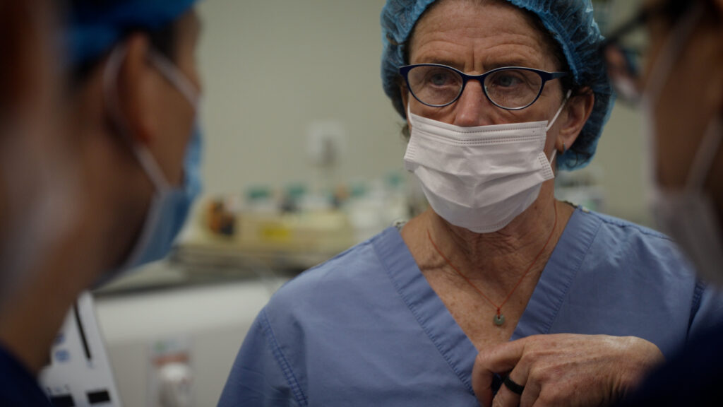 Dr. Sarah Tabutt talking to another medical professional in a surgery room.