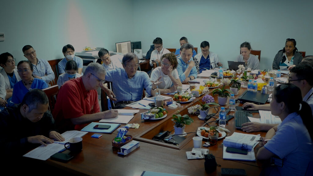 Clinicians packed into conference room in mid-discussion.