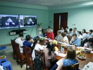 Large conference room filled with medical professionals discussing MRI images in front of the room.